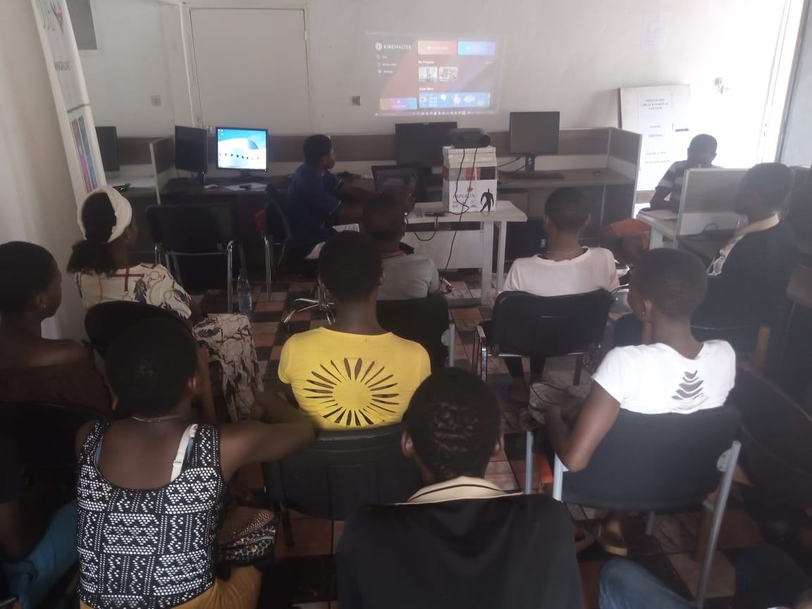 A group of people sitting in a room with computers

Description automatically generated with medium confidence